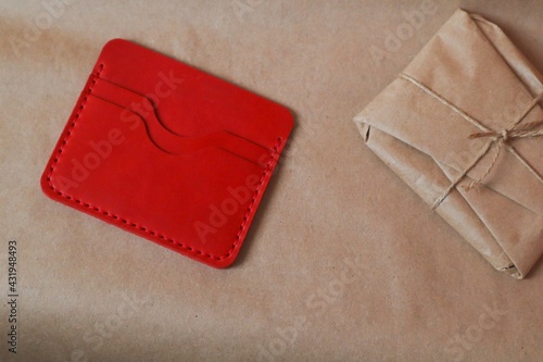 Leather wallet with a package wrapped in kraft paper 