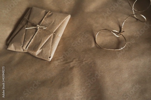 The package is wrapped in kraft paper and tied with thread