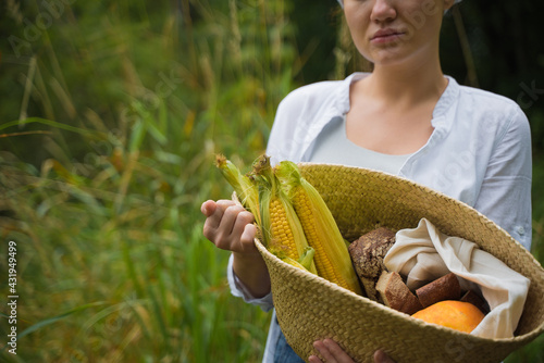 Farmer Girl with Basket with corn cobs on green , bread, pumpkin and flowers