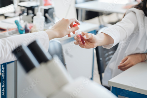 Crop view of researchers handing over laboratory sample