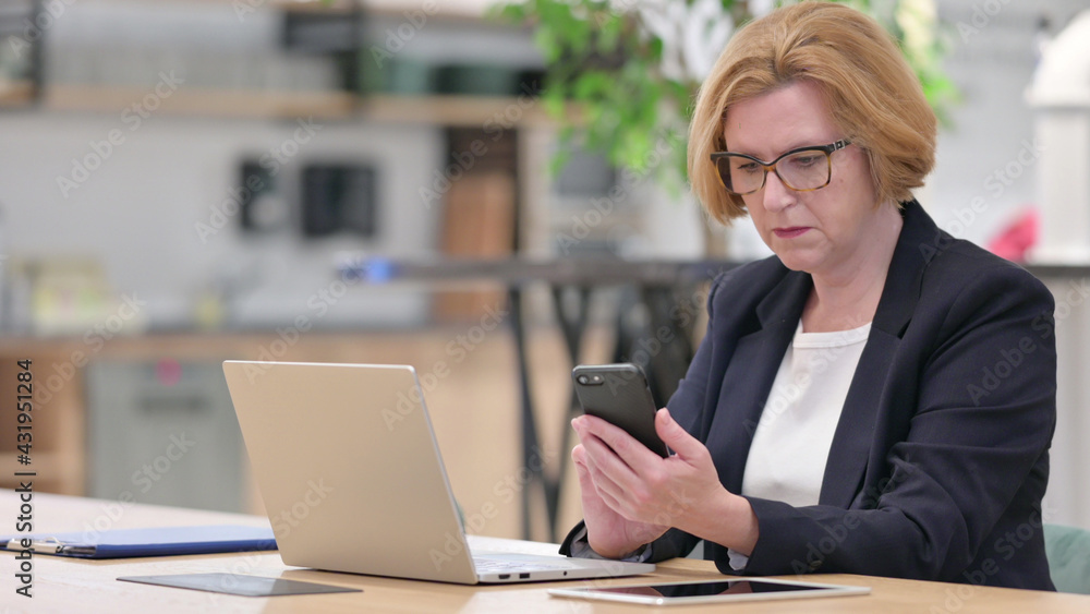 Old Businesswoman using Smartphone for Work Old Businesswoman using Smartphone for Work