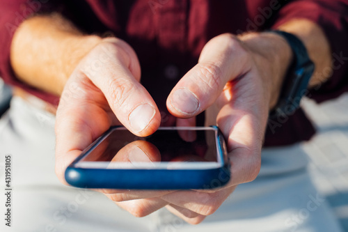 Businessman using smart phone while sitting outdoors photo