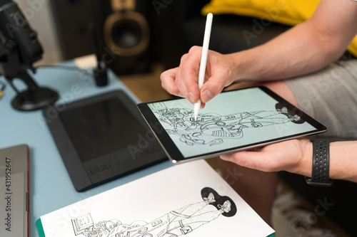 Artist drawing on digital tablet while live streaming sitting at home