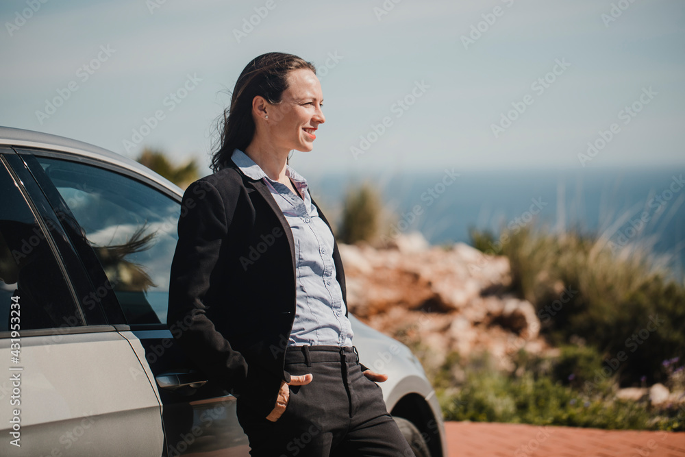 Confident entrepreneur standing with hands in pockets by car on sunny day Confident entrepreneur standing with hands in pockets by car on sunny day