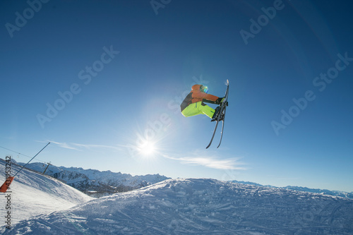 Male skier jumping against sky