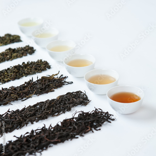 variety types of tea in little cups and natural tea leaves.