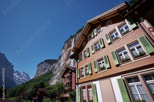 Traditional swiss village. Beautiful landscape with houses against Alps Mountains.
