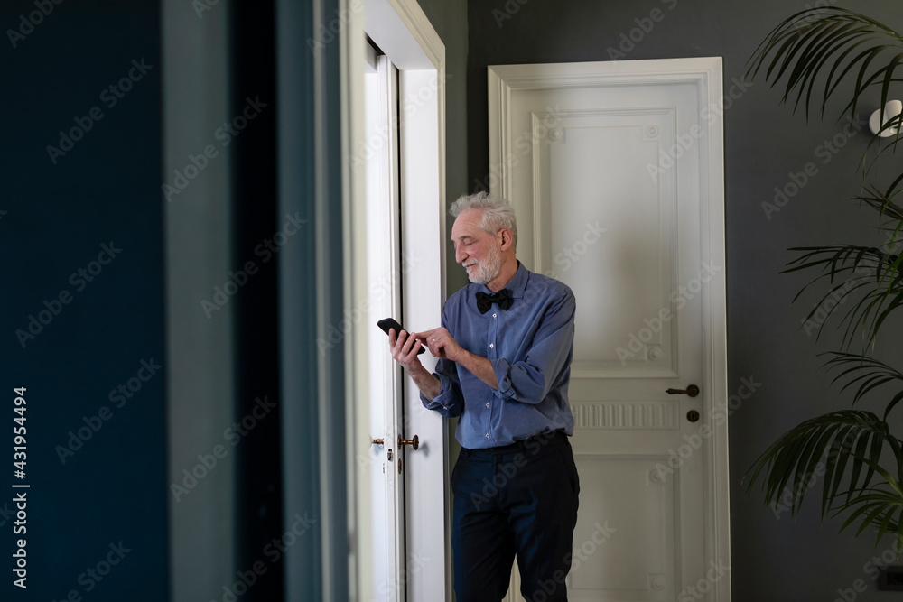 custom made wallpaper toronto digitalSenior man using phone while standing by window at home