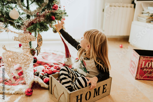 Happy family decorating christmas tree at home photo