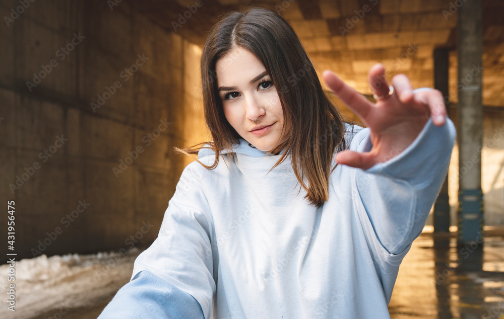 Young woman staring while stretching hand standing against underpass Young woman staring while stretching hand standing against underpass