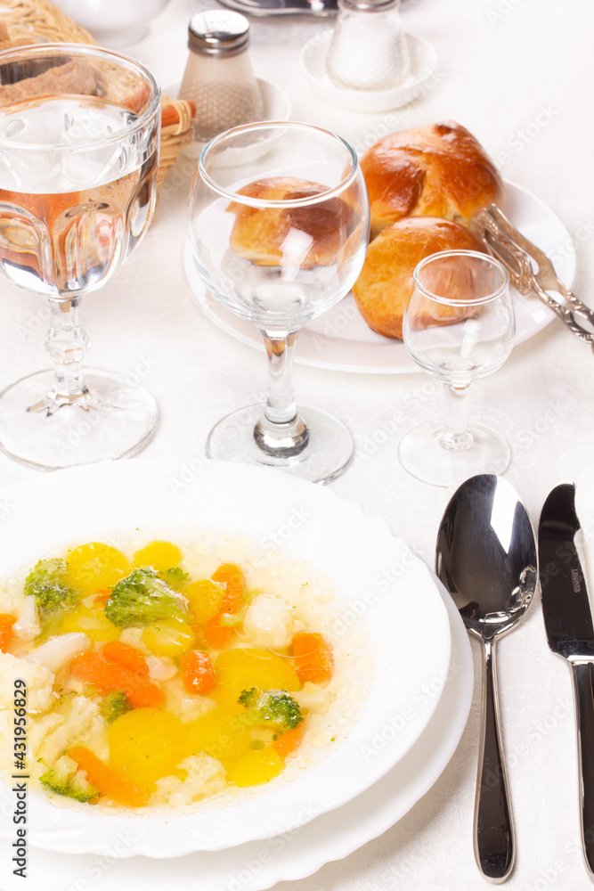 Plate with fresh hot soup on the table and homemade buns Plate with fresh hot soup on the table and homemade buns