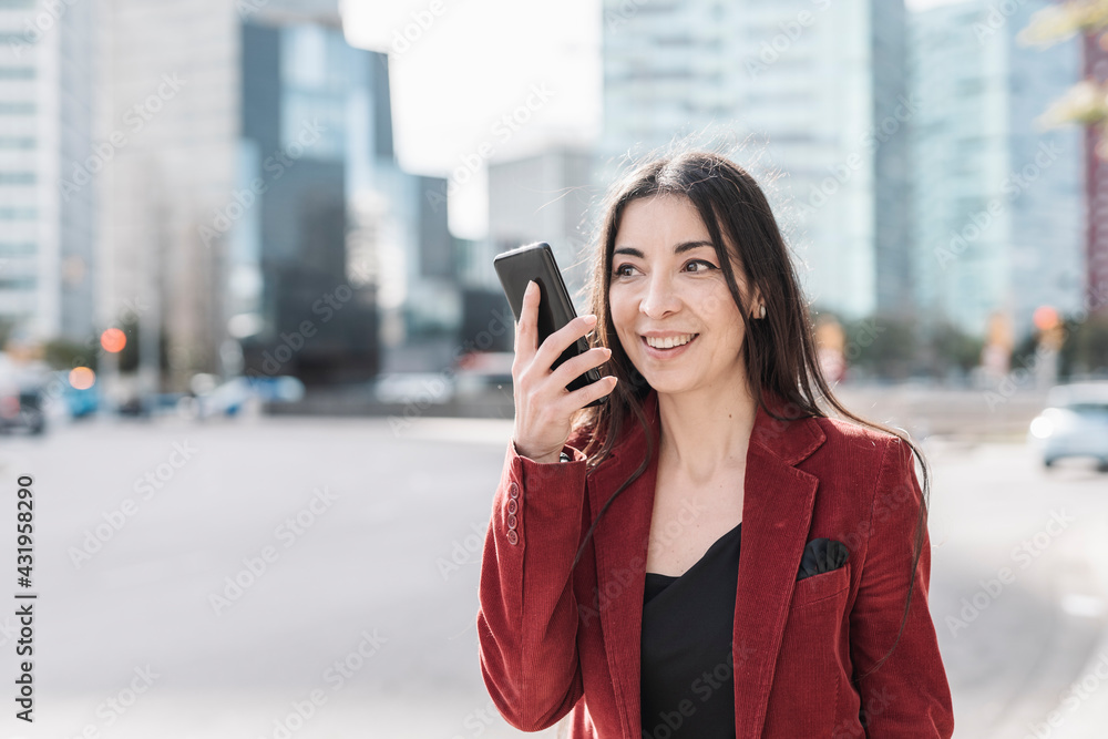 Smiling businesswoman talking on smart phone in city Smiling businesswoman talking on smart phone in city