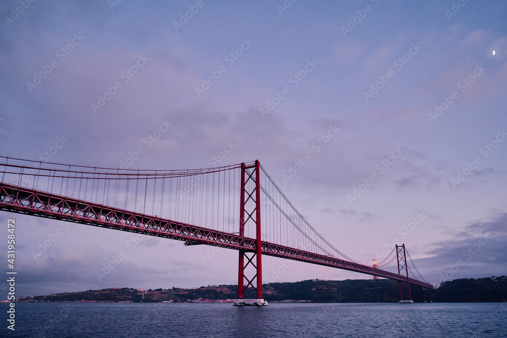 Beautiful landscape with suspension 25 April bridge bridge over the Tagus river in Lisbon, Portugal.