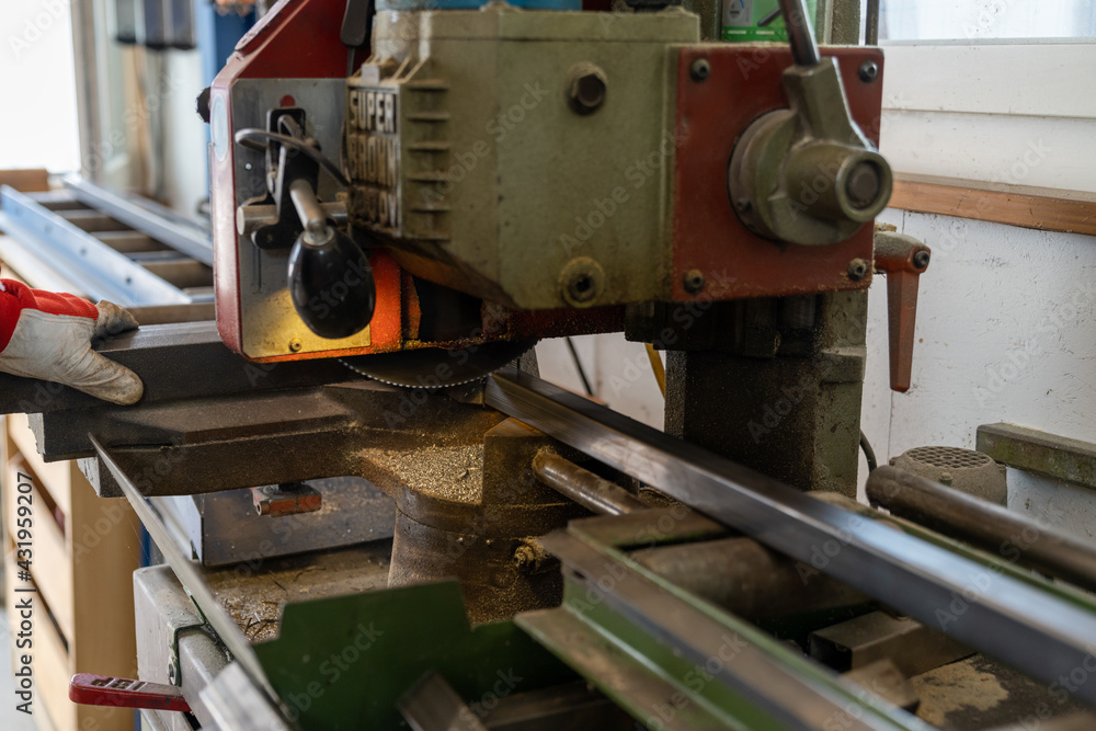 metal worker cutting steel with a steel band saw metal worker cutting steel with a steel band saw