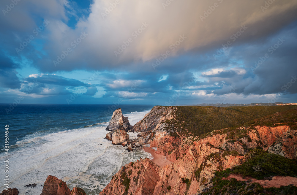 Portugal Ursa Beach at сoast of Atlantic Ocean. Rocks and waves at sand of coastline picturesque landscape.