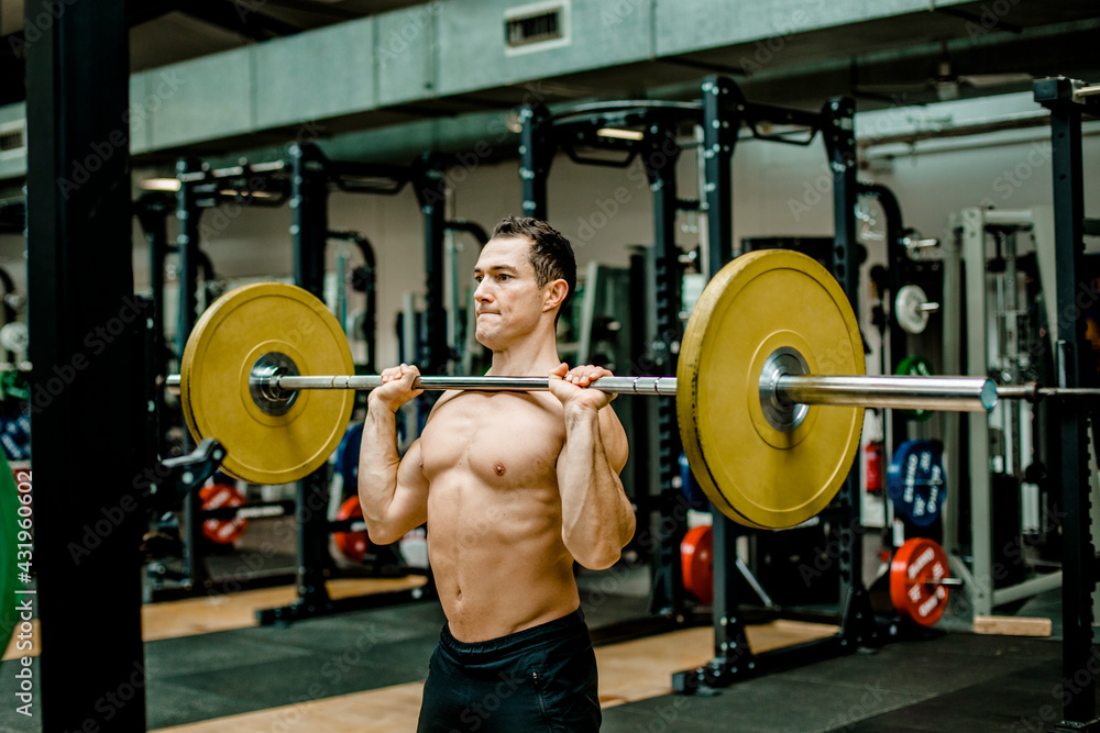 Strong man doing weightlifting exercise at gym Strong man doing weightlifting exercise at gym