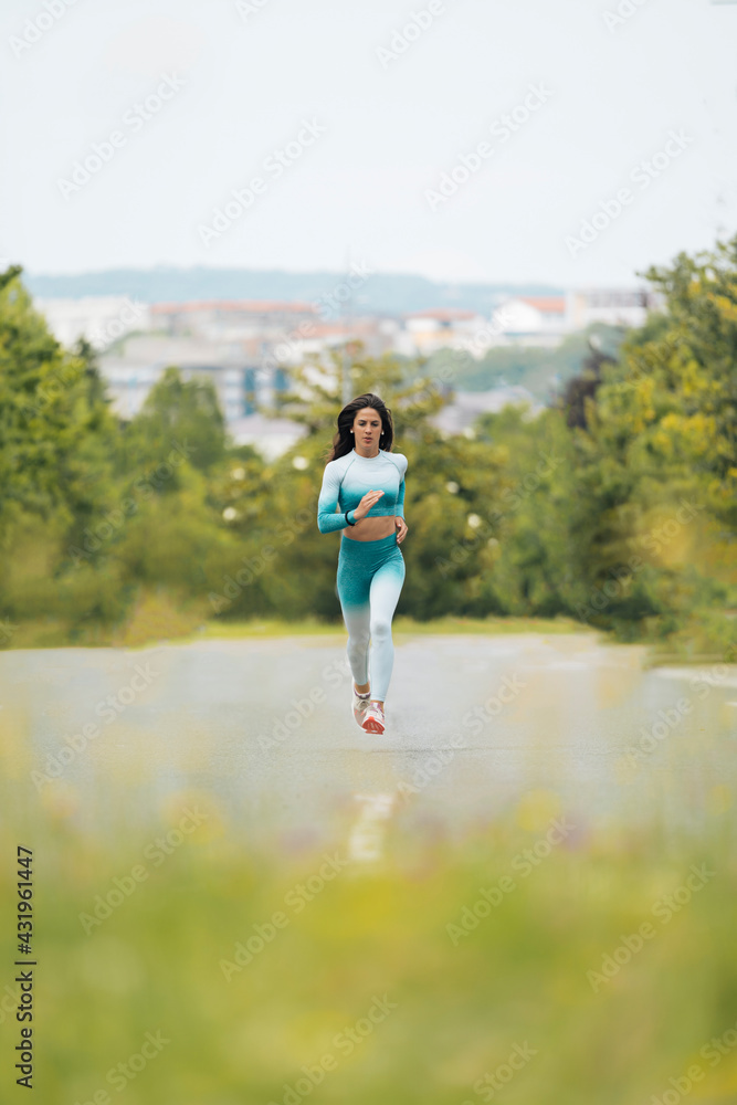 Young female athlete running on street Young female athlete running on street