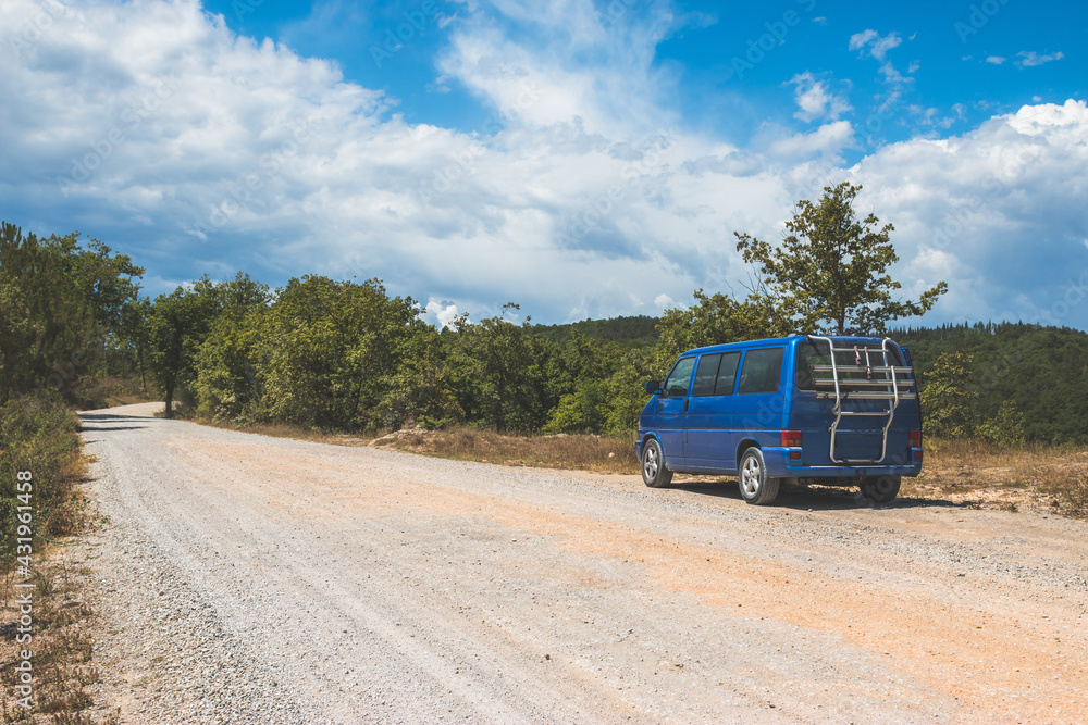 Camping adventure in the wilderness: Minivan is standing at the side of the desert road