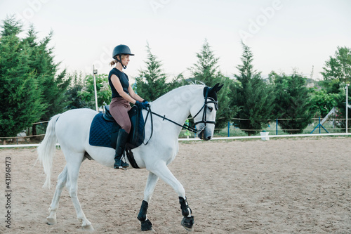Female doing horseback riding in farm photo