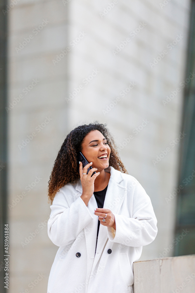 Young woman laughing while talking on smart phone Young woman laughing while talking on smart phone
