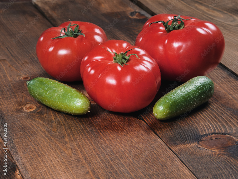 Fresh and juicy tomatoes and cucumbers on a wooden tabletop