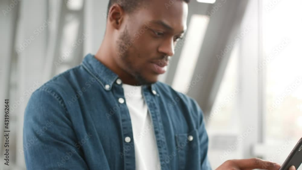 African American Tourist Guy Using Smartphone Standing In Airport African American Tourist Guy Using Smartphone Standing In Airport