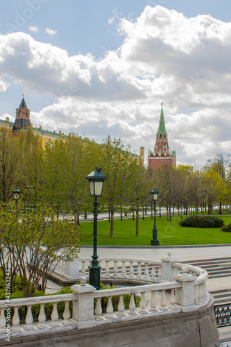 panoramic view of the Alexander Garden on a sunny spring day and green trees with the Borovitsky Tower and the yellow Funny Palace and the brick Kremlin wall in Moscow Russia photo