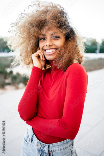 Smiling Afro woman standing with tousled hair