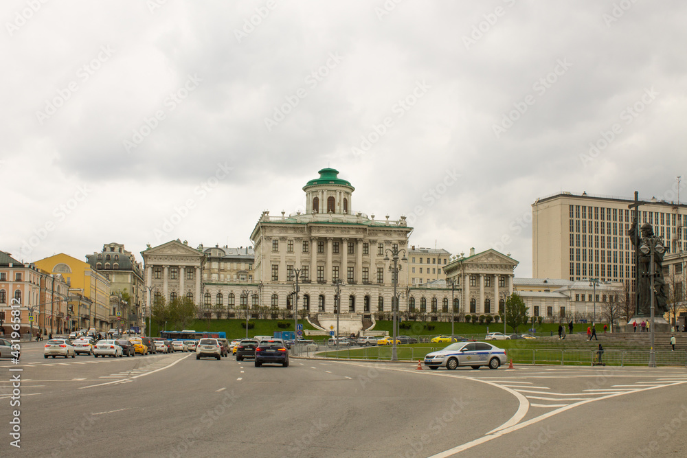 panoramic view of the white historical palace of the Peshkov House and passing cars against the background of a cloudy sky on a spring day. Concept-a famous place in Moscow Russia