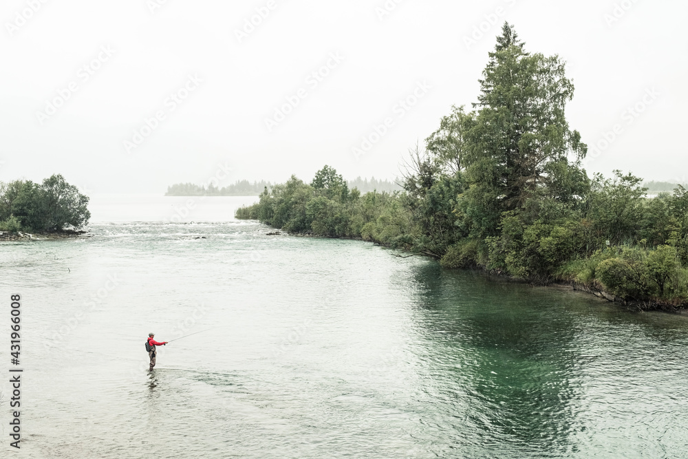 Fisherman doing fly-fishing in Loisach river at Kochelsee, Bavaria, Germany
