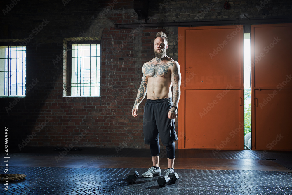 Shirtless male fitness coach standing at gym Shirtless male fitness coach standing at gym