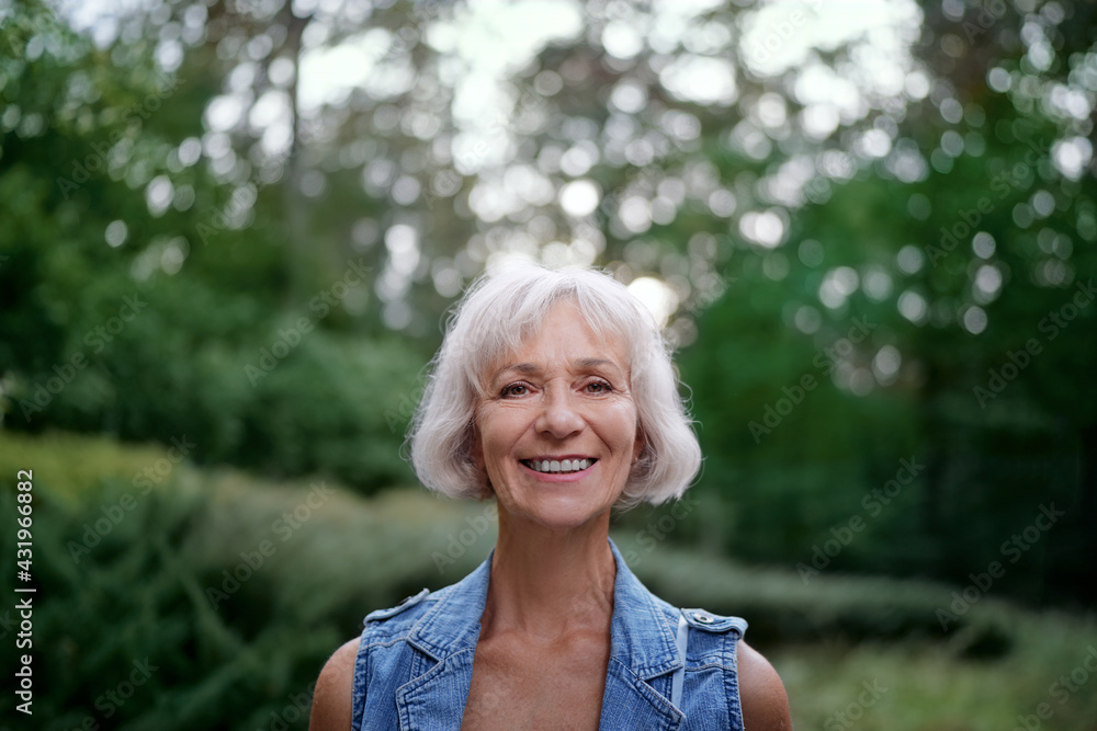 Portrait of happy elderly woman smiling and looking at camera outdoors. Portrait of happy elderly woman smiling and looking at camera outdoors.
