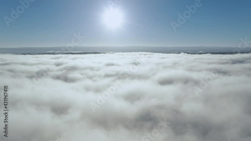Clouds and sun, drone rises above thick fog over the beautiful ocean of clouds at sunrise. Amazing natural scenery, 4K drone in the sky