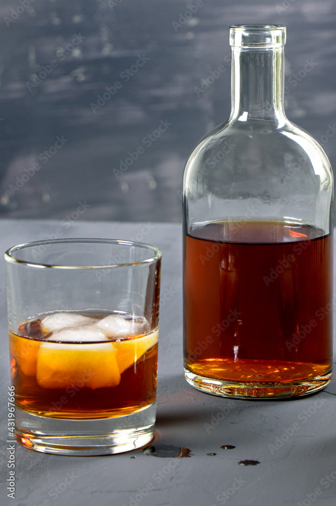 Alcohol. Bottle of whisky. A glass of scoth with ice. Copy space. Vertical orientation Alcohol. Bottle of whisky. A glass of scoth with ice. Copy space. Vertical orientation
