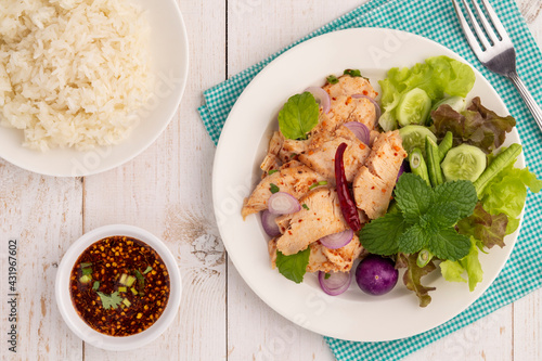 Flat lay sliced grilled chicken breast salad or nam tok gai n in Thai, a hot, sour, clean, healthy and lean dish in Isan Thai food style, served with sticky rice, Jaew dipping sauce and vegetables.