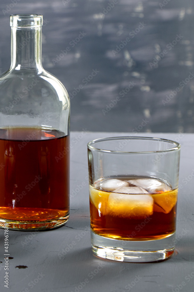 Alcohol. Bottle of whisky. A glass of scoth with ice. Copy space. Vertical orientation Alcohol. Bottle of whisky. A glass of scoth with ice. Copy space. Vertical orientation