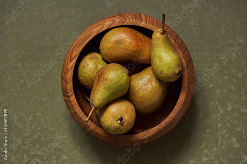 Ripe pears in wooden bowl