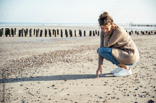Young woman with squatting position on sand at beach
