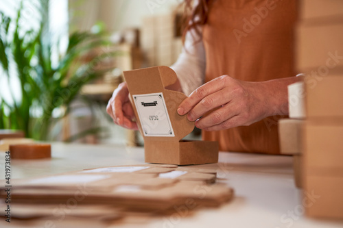 Woman folding boxes for packaging of handmade soaps photo