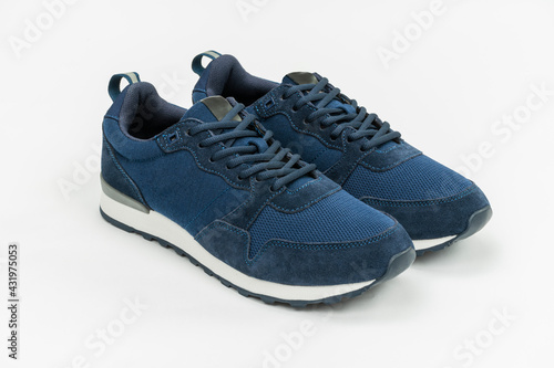 NEW BLUE, CASUAL, FASHIONABLE AND STYLISH SNEAKERS ON WHITE BACKGROUND. SPORTSWEAR, SHOPPING AND GIFTS CONCEPT.