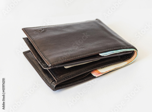 black wallet full of money on a white background. economy concept