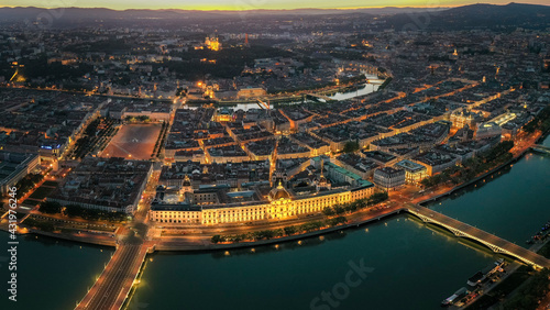France, Auvergne-Rhone-Alpes, Lyon, Aerial view of illuminated city situated at confluence of Rhone andÔøΩSaoneÔøΩrivers at dusk photo