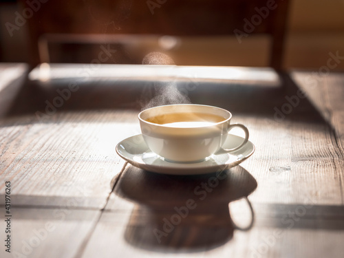 Cup of hot green tea on wooden surface