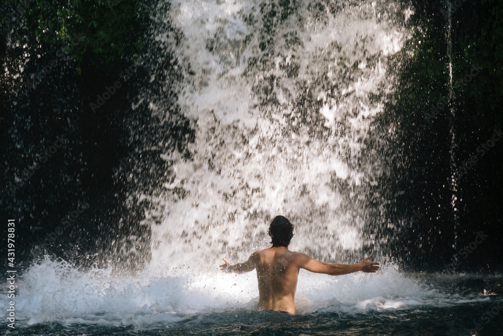 Indonesia, Bali, Man bathing in waterfall Indonesia, Bali, Man bathing in waterfall