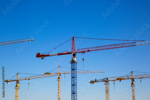 Germany, Bavaria, Munich, Construction cranes against blue sky photo