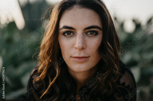 Confident young woman with brown eyes during sunset photo