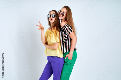Two young women in stylish clothes fashion beauty studio shot on white background
