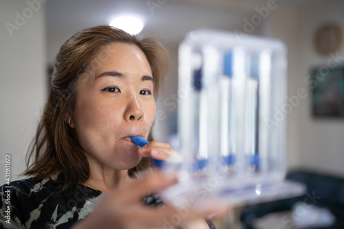 A woman uses a Tri-ball Incentive Spirometer for check his lung function. photo