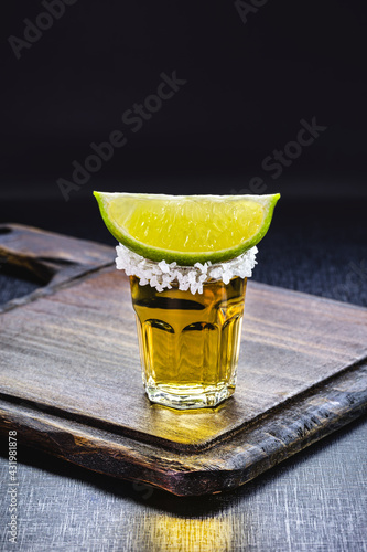 glass of tequila, black background, typical mexican drink