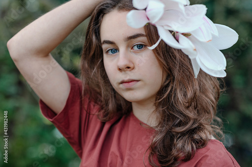 Girl with blue eyes wearing magnolia flower in hair photo